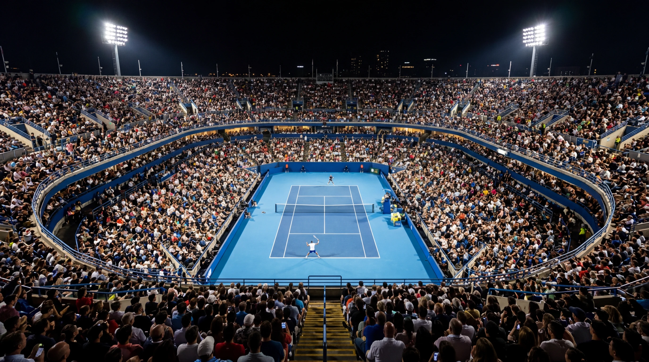 Estadio de tenis lleno de publico durante un partido nocturno con iluminacion profesional